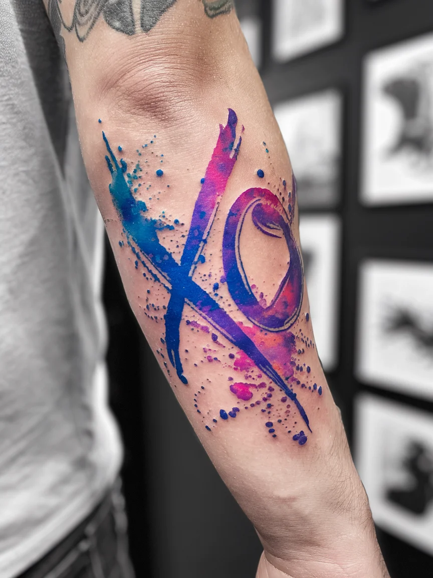Watercolor XO tattoo on forearm