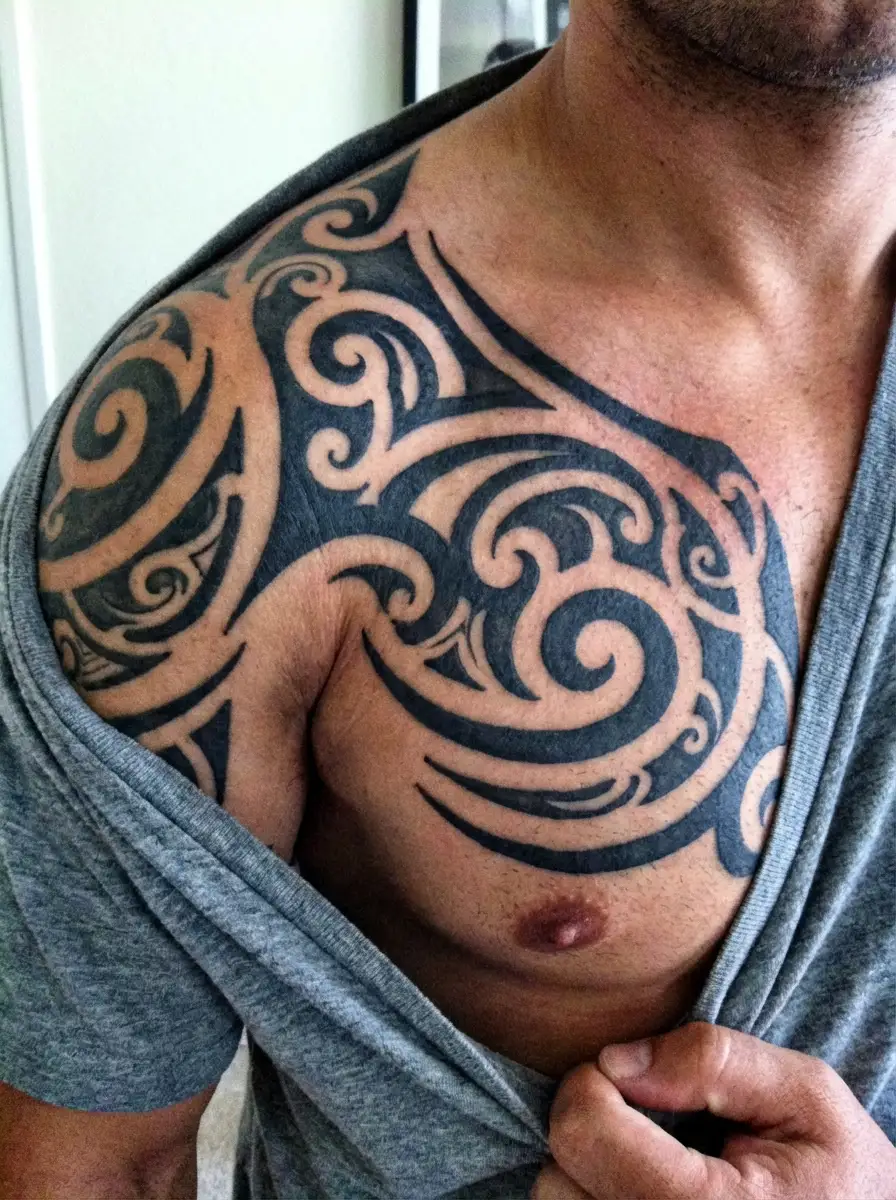 man with tribal shoulder to chest tattoo