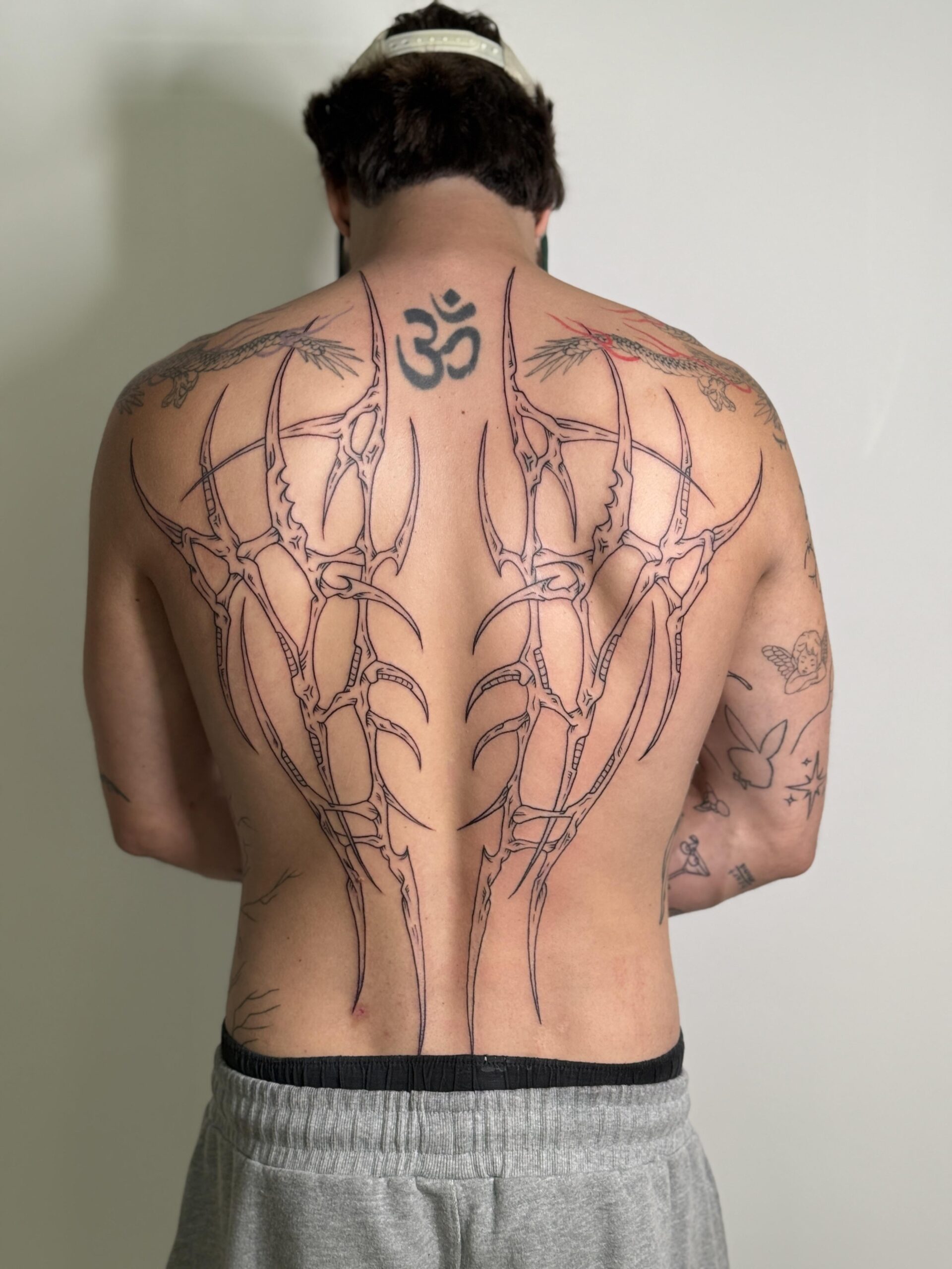Symmetrical neo-tribal back tattoo