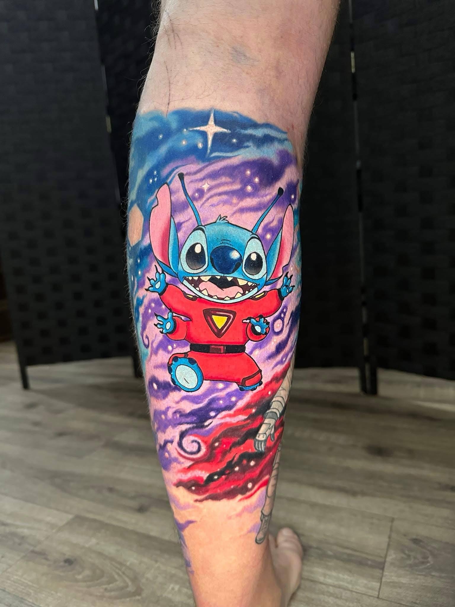 Vibrant space-themed Stitch leg tattoo