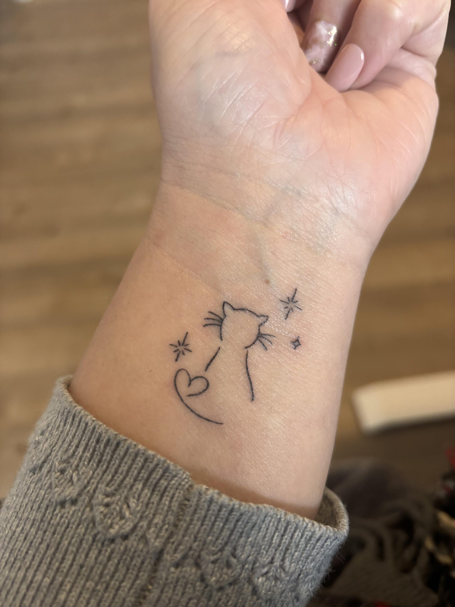 Minimalist cat silhouette line tattoo