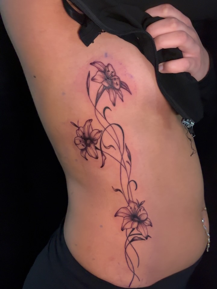 Elegant Stem and Flower Ribcage Tattoo