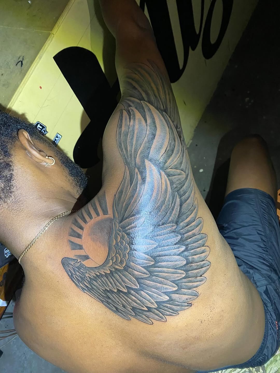 Detailed Wing and Sun Tattoo