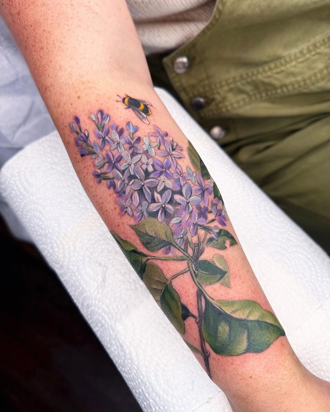 Vibrant lilac and honeybee forearm tattoo