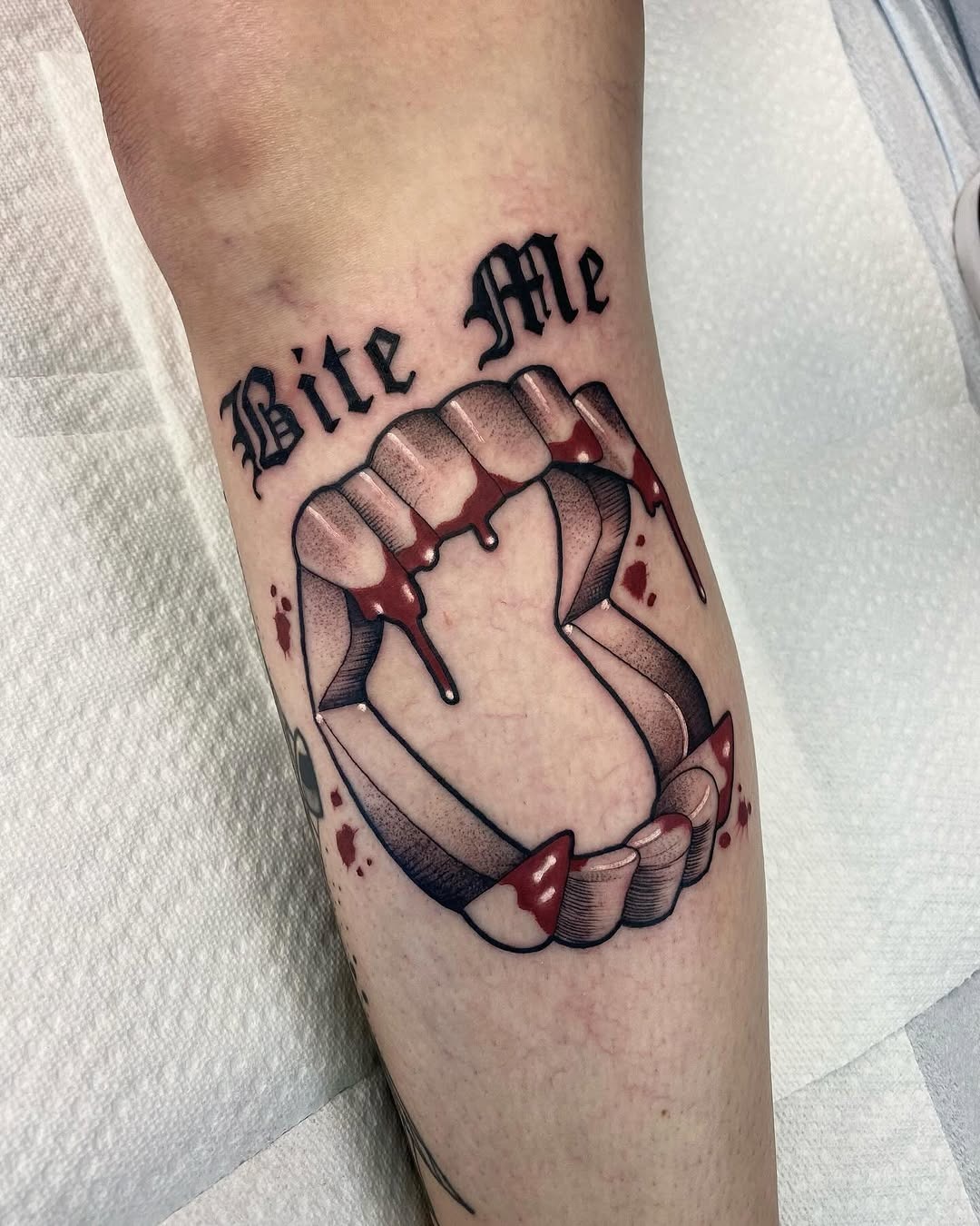 Artistic 'Bite Me' vampire fangs tattoo
