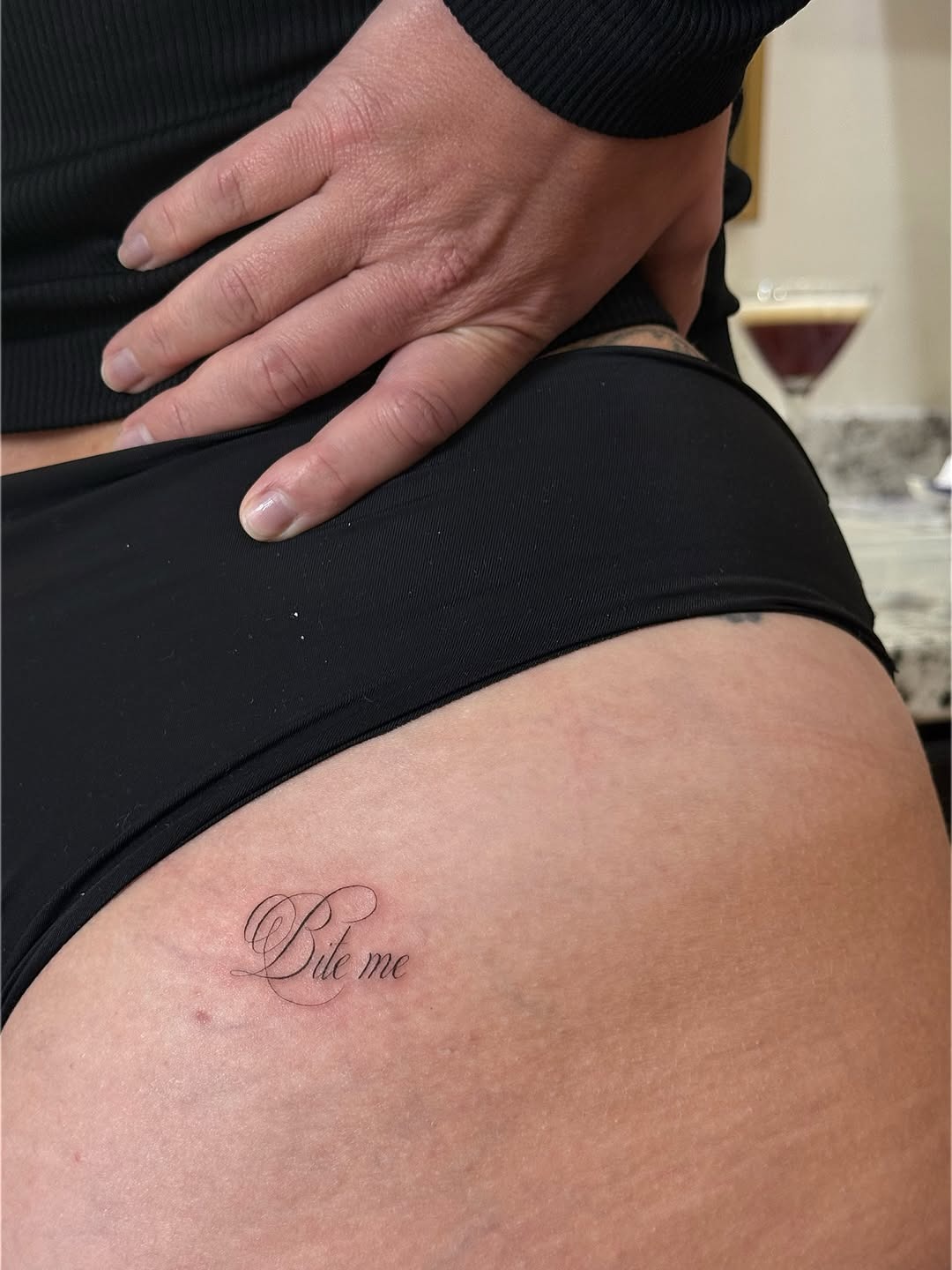 Fine-line 'Bite Me' script tattoo