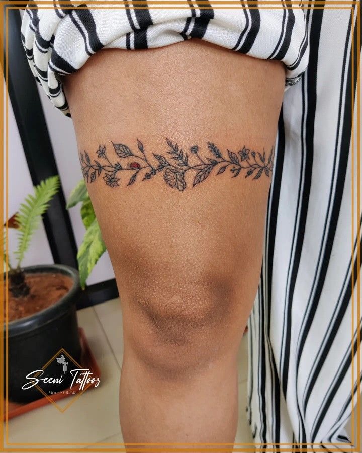 Delicate floral winding thigh tattoo