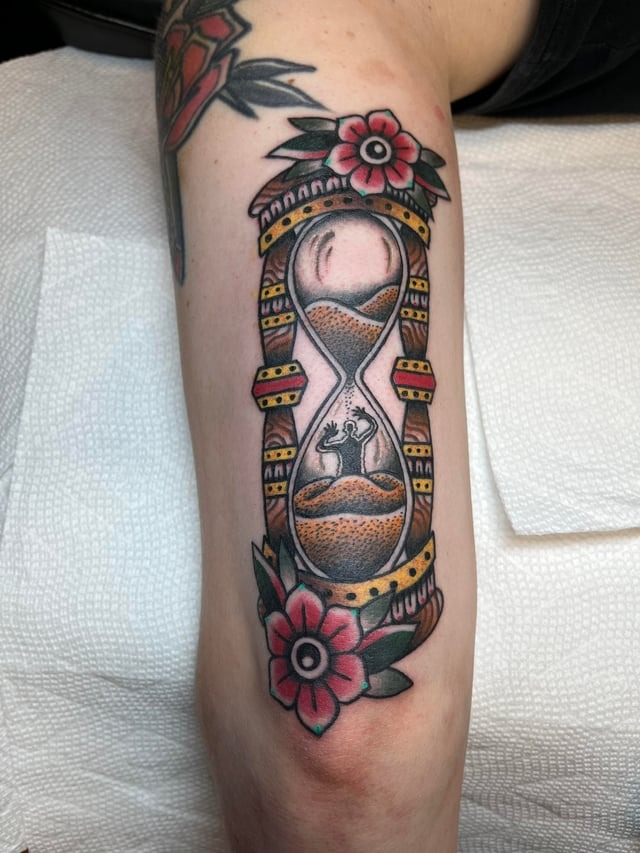 Vibrant traditional hourglass arm tattoo