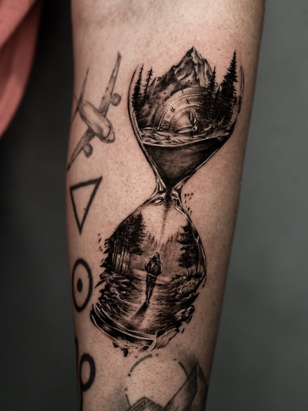 Intricate mountain and travel hourglass tattoo