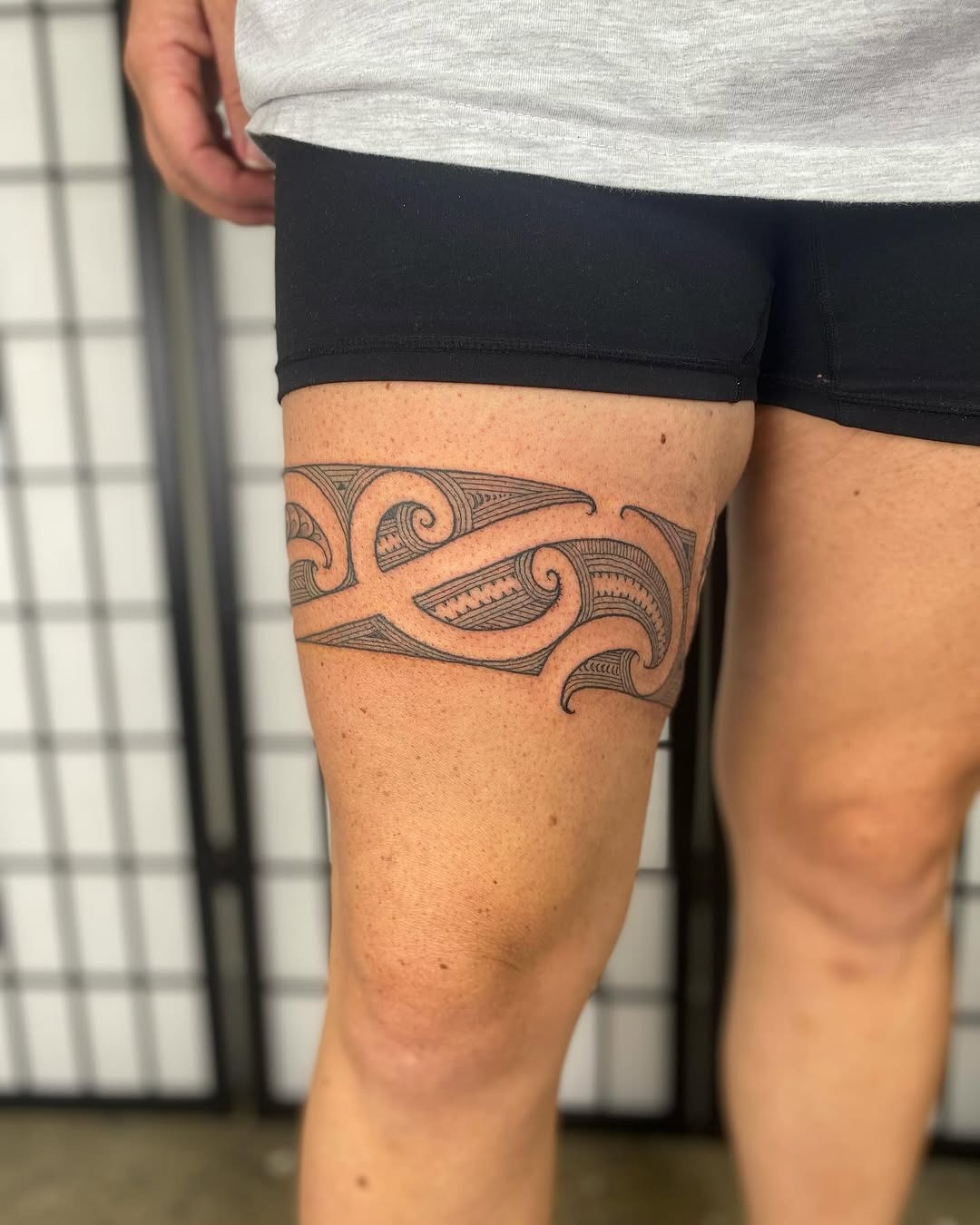 Bold tribal band thigh tattoo