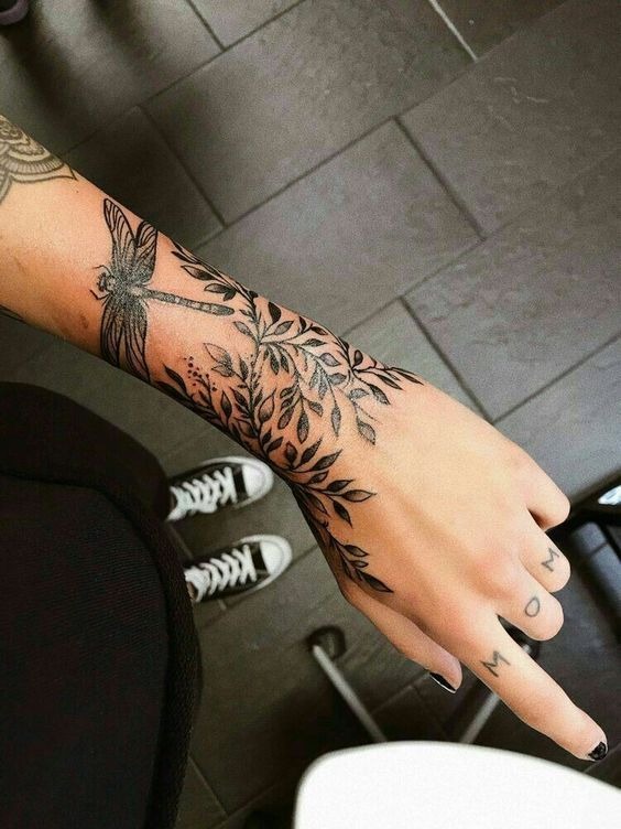 Detailed floral dragonfly wrist tattoo art