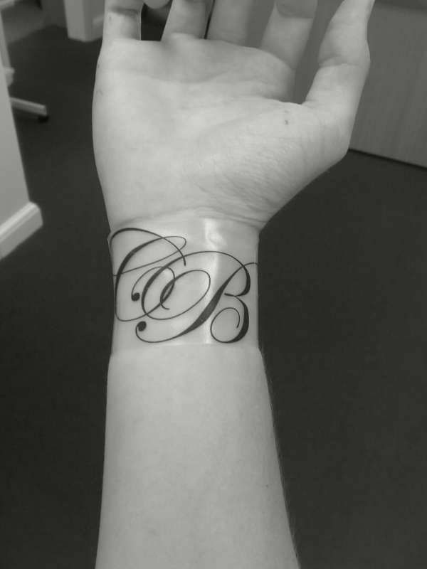 Sophisticated minimalist initial wrist tattoo