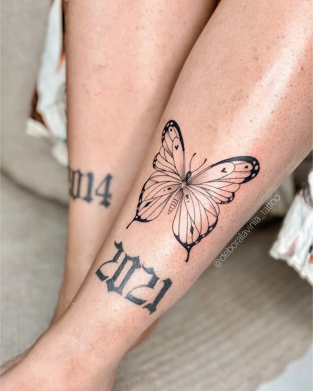 Minimalist butterfly and year tattoo