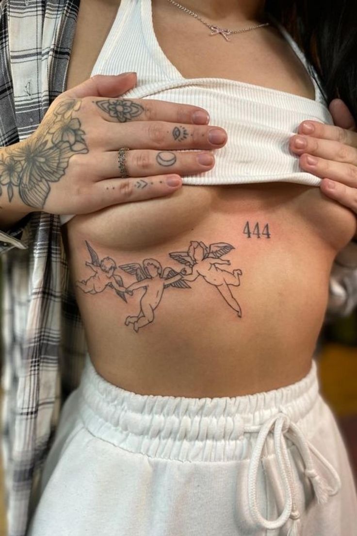 Delicate cherub line-art under-breast tattoo