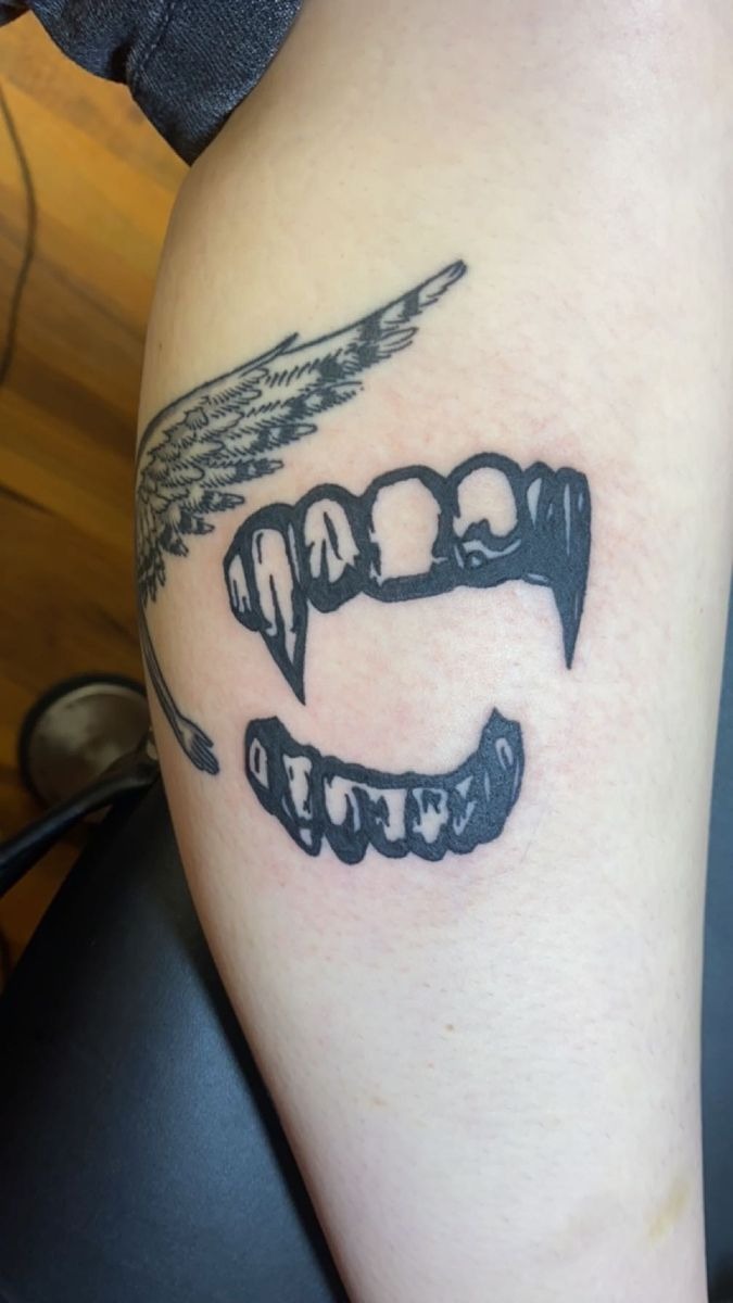 Bold vampire fang tattoo design