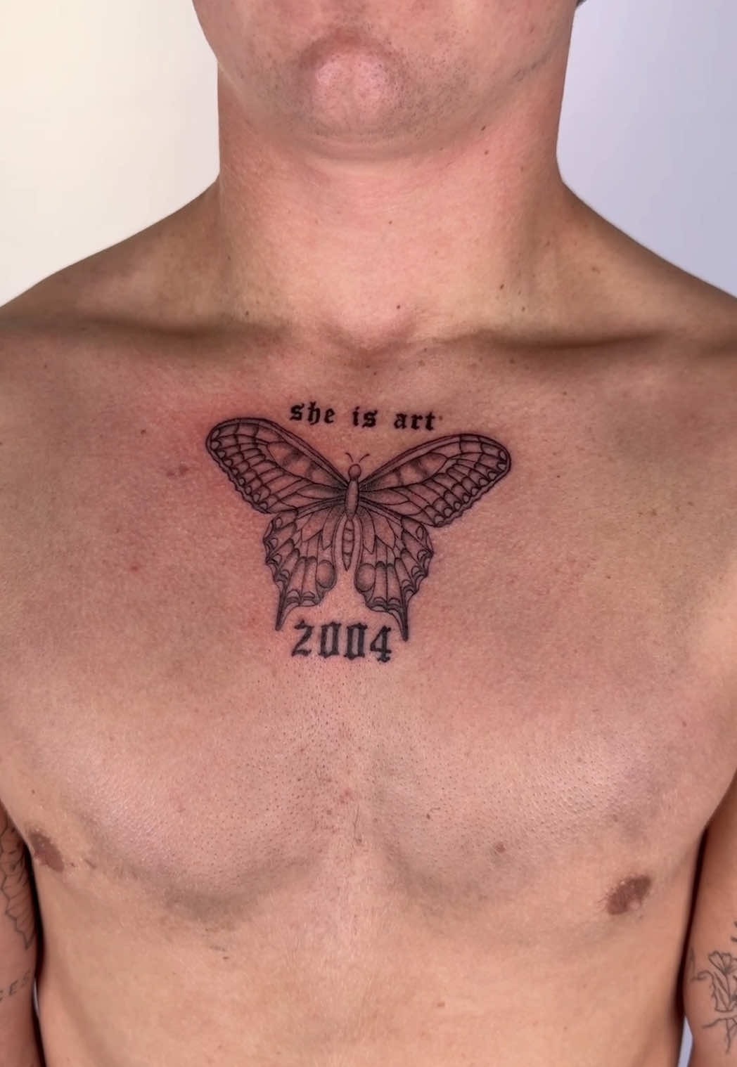 Minimalist butterfly chest tattoo