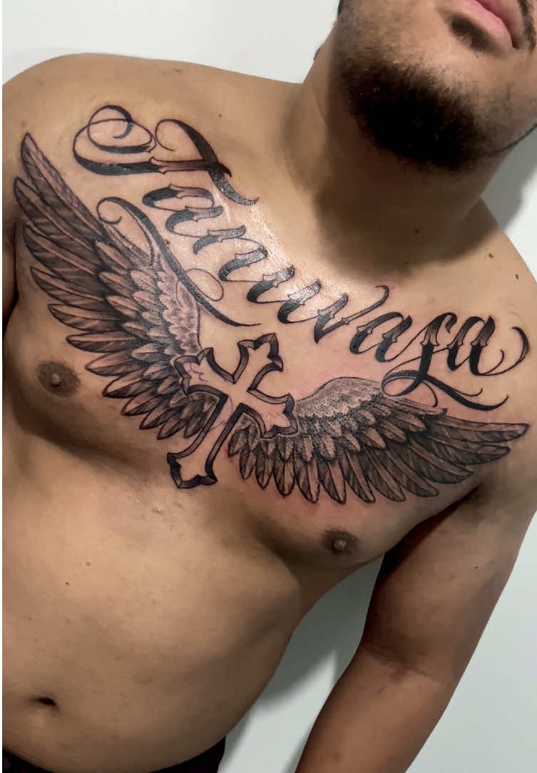 Winged cross centerpiece chest tattoo