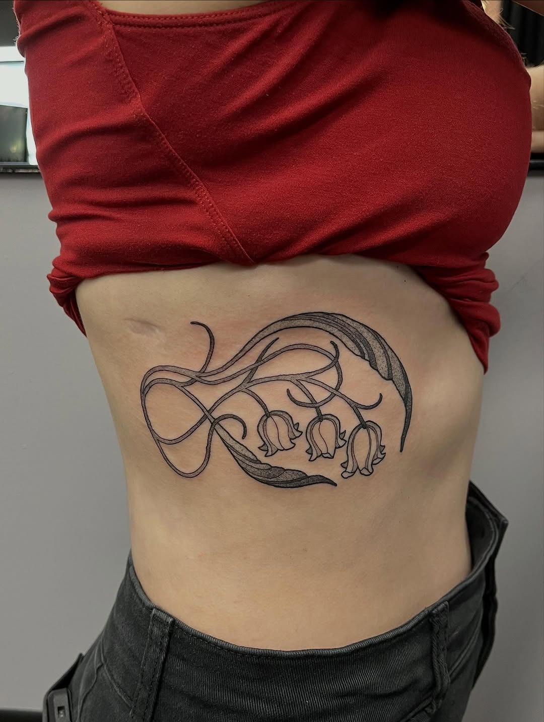 Elegant Minimalist Lily of the Valley Rib Tattoo